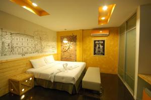卡马拉海滩SHA The Regent Resort Phuket Kamala Beach的卧室配有一张床和墙上的绘画