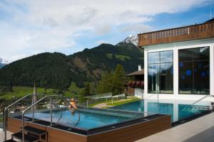 东蒂罗尔地区马特赖戈德里德酒店的一座房子,设有一座山地游泳池