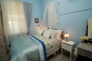 布罗肯希尔艾拉度假屋的蓝色的卧室配有一张床和一张带台灯的桌子