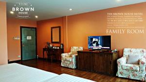北柳布朗之家酒店的一间卧室配有一张床、两把椅子和一台电视