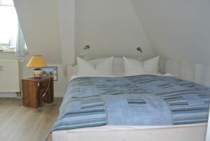 奥斯赛拜-屈隆斯博恩Hotel Rosenhof的一间卧室配有一张带蓝色棉被的大床