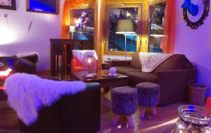 拜兰特里VVF La Plagne Montchavin Paradiski的客厅配有紫色家具和带凳子的桌子