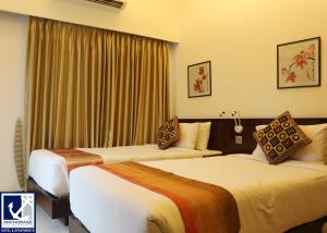 达卡安克雷奇酒店的配有窗帘的酒店客房内的两张床
