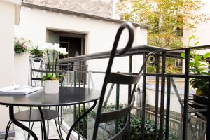 巴黎伟人酒店的阳台上配有一张黑色的桌子和椅子