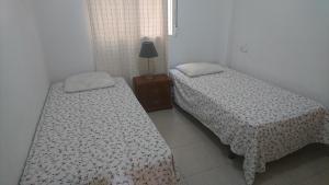 穆尔西亚Apartment La Huerta de Beniajan 50 por ciento dcto directo的两张睡床彼此相邻,位于一个房间里