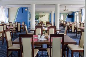 鲁恰内尼达尼兹奇酒店的用餐室配有木桌和椅子