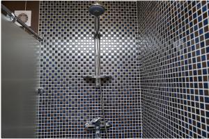 卡拉甘达Apartment on Pichugina的浴室铺有黑白瓷砖,设有淋浴。