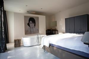 奥斯特豪特Stalen Boshuis的一间卧室设有一张大床和一个浴缸