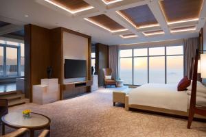 青岛青岛山港凯悦酒店 （石老人海水浴场·会展中心）的配有一张床和一台平面电视的酒店客房