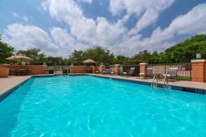 印第安纳波利斯印第安纳波利斯机场凯悦嘉轩酒店的一个带椅子和围栏的大型蓝色游泳池