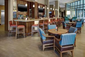 德尔雷比奇凯悦广场德拉海滩酒店的一间带桌椅的餐厅和一间酒吧