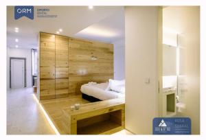波尔图ORM - Ribeira Apartments的一间卧室设有一张床和木墙