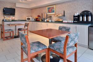 温莎Lexington Inn & Suites-Windsor的厨房配有木桌和椅子
