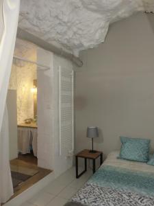 吕讷Gîte en Touraine的一间卧室配有一张床和一张带台灯的桌子