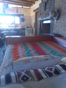 圣拉斐尔Hogar de Campo的一间卧室配有一张带彩色毯子的床