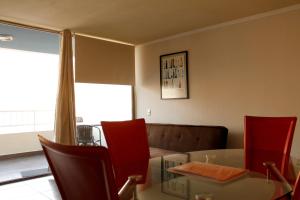 伊基克Iquique Playa Brava 1670的客厅配有玻璃桌和红色椅子