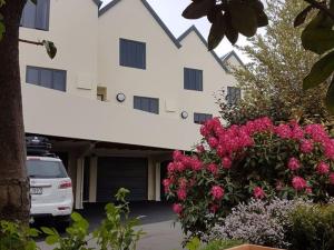 基督城Bella Vista Motel & Apartments Christchurch的停在一座花粉的建筑前面的汽车