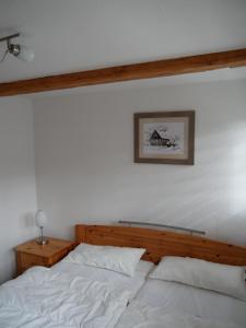 库罗阿尔滕堡Ferienhaus Am Skihang的一张铺有白色床单的床和一张墙上的照片
