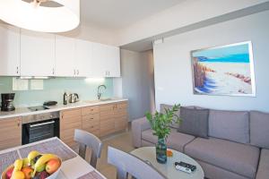 加藤-达拉特索Sonja Beachfront Apartments的厨房以及带一碗水果桌的起居室。