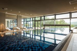 GonnesweilerSeezeitlodge Hotel & Spa的享有水景的大楼内的游泳池