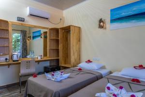 图杜马尔代夫托多轻松旅馆的客房设有两张床和一张书桌