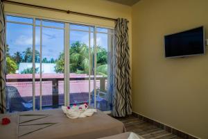 图杜马尔代夫托多轻松旅馆的客房设有大窗户和电视。