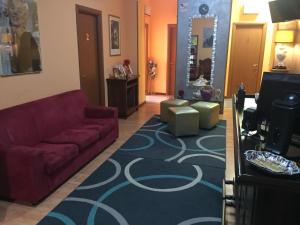 圣雷莫洛坎达比特莱斯旅馆的客厅配有红色沙发和蓝色地毯