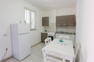 庞特卡格纳诺Camping Lido di Salerno的厨房配有白色桌子和白色冰箱。