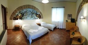 巴蒂帕利亚Farmstay La Morella的一间卧室设有两张床,墙上挂着一幅画