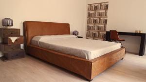 贝加莫印第斯阿特套房酒店的一间卧室设有一张床和一个书架