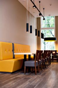 阿姆斯特丹阿姆斯特丹城市酒店的一间带黄色沙发和椅子的用餐室