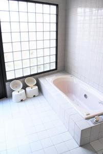 大分Hotel Pal Furugou (Love Hotel)的白色浴室设有2个卫生间和浴缸。