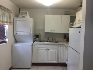 NCASagusta Gardens NCA的白色的厨房配有水槽和冰箱