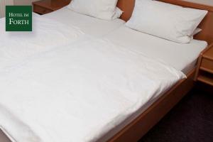 奥伊滕艾姆弗斯酒店的一张带白色床单和枕头的床铺