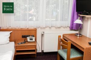 奥伊滕艾姆弗斯酒店的客房设有书桌、床和电话。