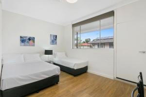 班克斯镇澳大利亚社区村庄旅馆的一间卧室设有两张床和窗户。