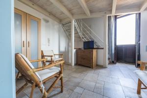 莫诺波利Appartamento Selene的客厅配有椅子、电视和楼梯