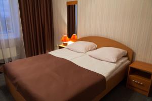 沃洛格达斯帕萨凯酒店的一间卧室配有一张大床,上面有两盏灯