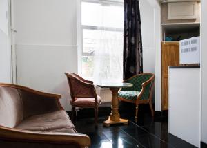 伦敦加勒多念一室公寓的客厅配有椅子、桌子和窗户