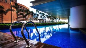 吉隆坡塔拉贡时间服务套房公寓的一座游泳池,旁边设有两个金属扶手
