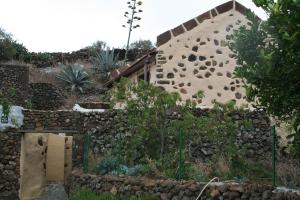La TorreCasa Rural Poblado Jirdana的一座石墙和围栏的房子