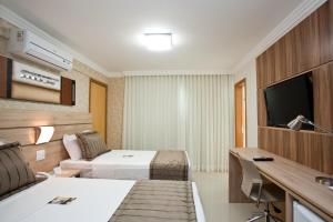 贝洛奥里藏特BH Jaraguá Hotel的配有一张床和一台平面电视的酒店客房