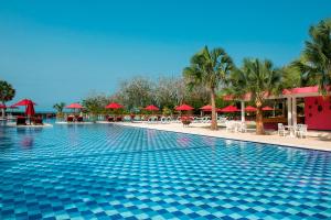 布兰卡滩巴鲁得可麦仑酒店&度假村 - 全包 的一个带红伞的度假村的游泳池