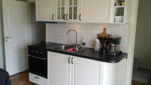 乌拉勒德Sjönära Ullared的厨房配有白色橱柜和水槽