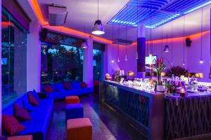卡塔赫纳卡塔赫纳得可麦仑全包酒店的餐厅内拥有蓝色和紫色照明的酒吧