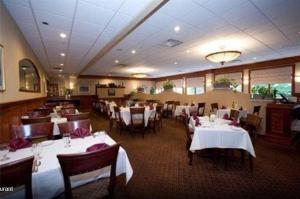 韦斯特利Winnapaug Inn的一间设有白色桌椅的用餐室和一间餐厅