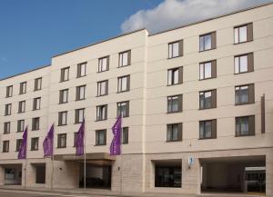 威斯巴登威斯巴登市美居酒店的前面有紫色旗帜的建筑