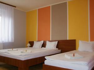 热舒夫泊克叶盖斯内民宿的橙色和黄色墙壁的客房内的两张床