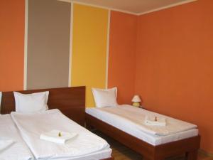 热舒夫泊克叶盖斯内民宿的橙色和黄色墙壁的客房内的两张床