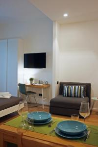 米兰米兰纳威格力公寓 - 托尔托纳大街的客厅配有带盘子和酒杯的桌子